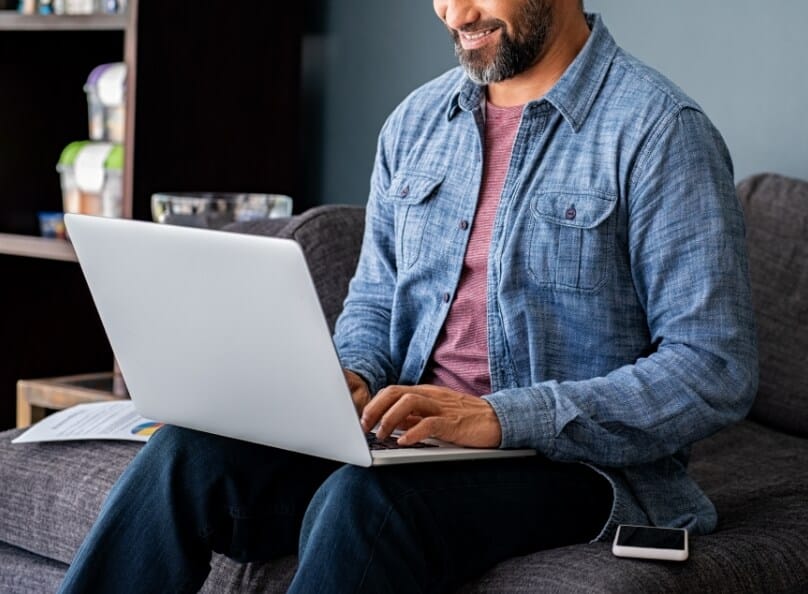 Person sitting down and engaging with a laptop computer