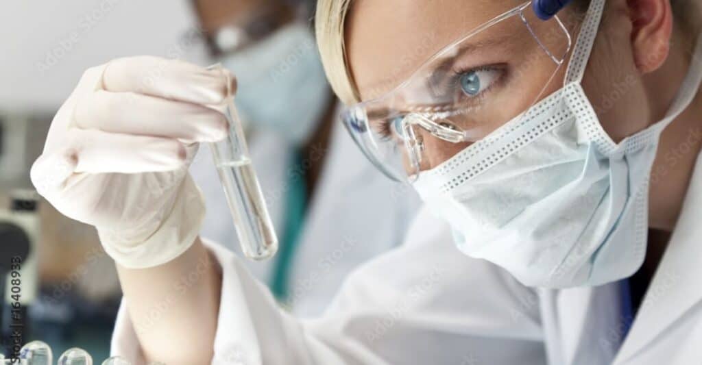 Researcher holding a vial and looking at it